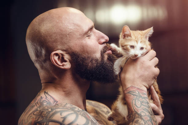 istock brutal tattooed man with cat 1285092896