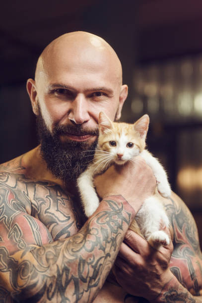 istock brutal tattooed man with cat 1285093684