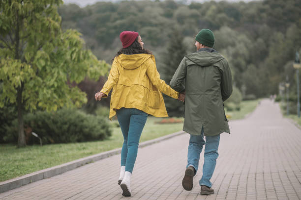 istock Young couple running in the park and looking cheerful 1285094735