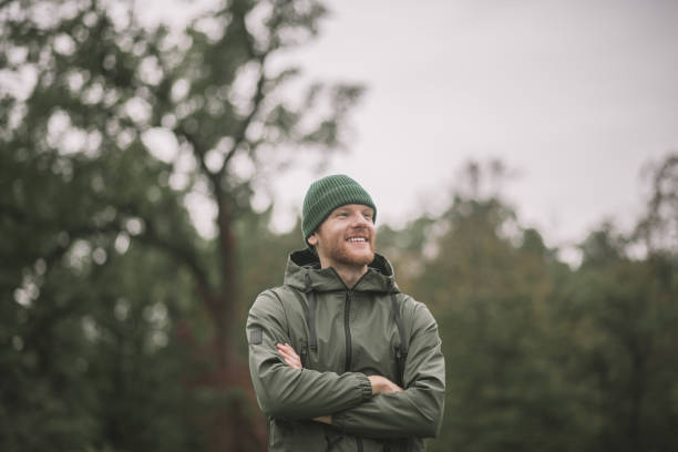 istock Young man in a green coat standing in the park 1285094745