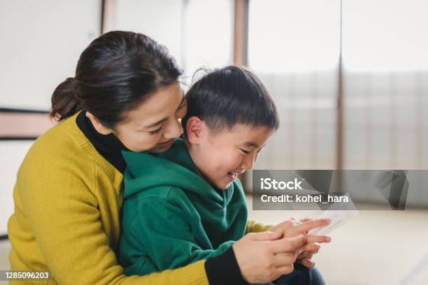 日本の母と息子が正月カードを読む