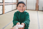 おとじ玉を手渡す日本人の父の手、お正月に贈り物として与えられたお金を息子に