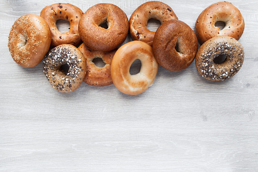 Stack of mixed New York style bagels across the top edge of the frame with copy space below