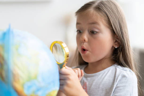 istock education and school concept. child girl pointing at globe. 1285097953