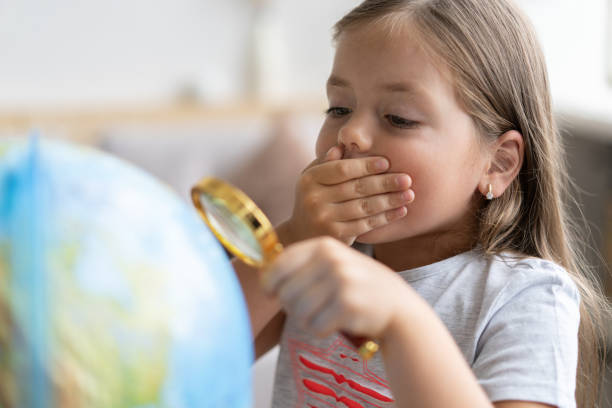 istock education and school concept. child girl pointing at globe. 1285097957