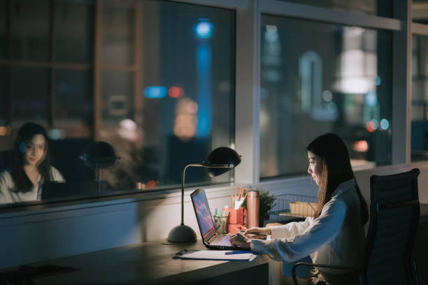 asiática china mujer trabajadora de cuello blanco que trabaja tarde en la oficina solo en la noche corriendo para informe financiero - effort dark concepts women fotografías e imágenes de stock