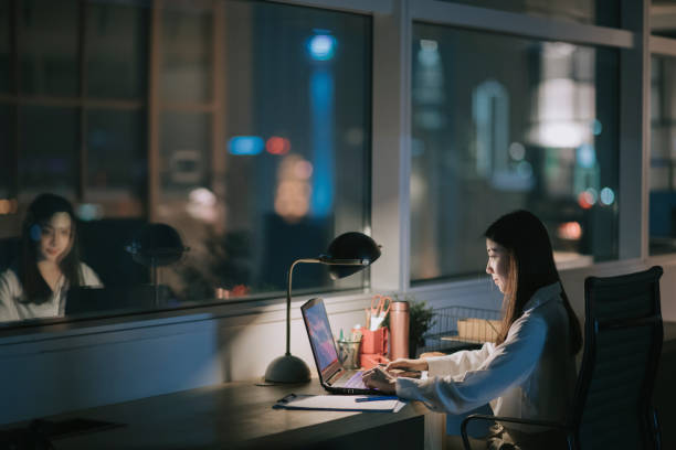 asian chinese female white collar worker working late in office alone at night rushing for financial report asian chinese female white collar worker working late in office alone at night rushing for financial report leanincollection stock pictures, royalty-free photos & images