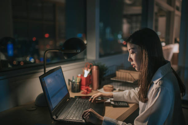 istock asian chinese female white collar worker working late in office alone at night rushing for financial report 1285099731