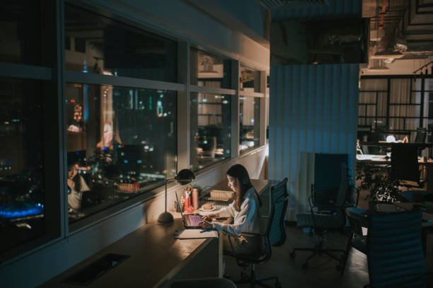 asian chinese female white collar worker working late in office alone at night rushing for financial report asian chinese female white collar worker working late in office alone at night rushing for financial report working late stock pictures, royalty-free photos & images