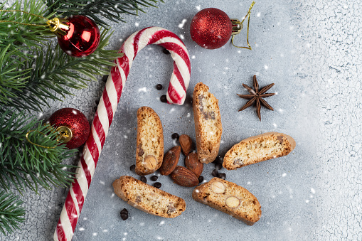 Traditional Italian biscotti or Cantuccini cookies with almonds, chocolat andwalnuts on a gray background with almond and chocolat, a Christmas tree. The concept of Christmas baking.