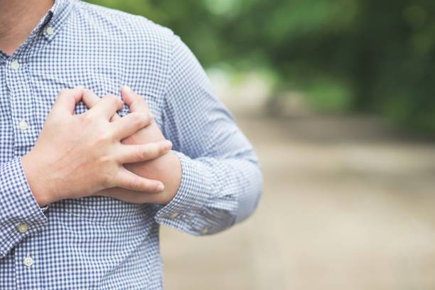 man hold his hand on breast look like heart attack stock photo