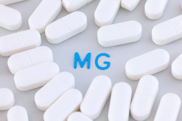 Magnesium pills around the symbol Mg Magnesium pills around the symbol Mg. Close up. magnesium deficiency stock pictures, royalty-free photos & images