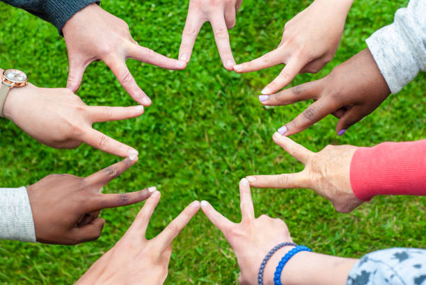 istock Black and white people forming nine pointed star with their fingers. 1285106055