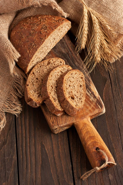 istock Bread slices on wooden background 1285106483