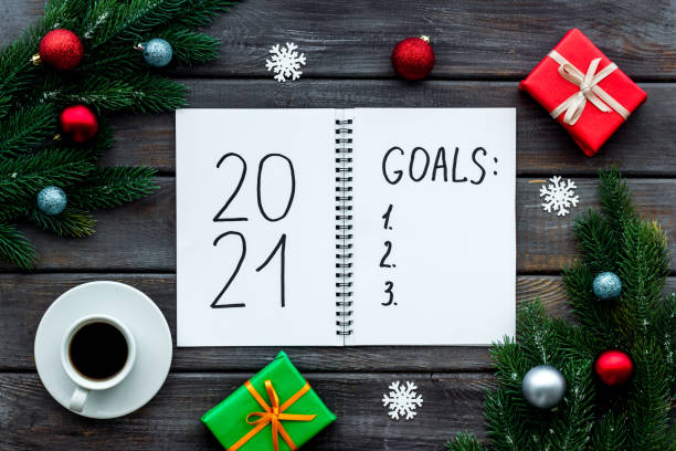 istock Top view of 2021 goals list with decorations and notebook on a table, flat lay 1285108192