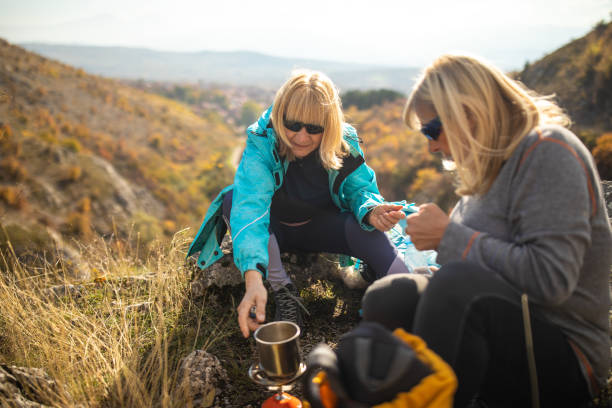 istock Female friends making a coffee while taking a break during hiking 1285109952