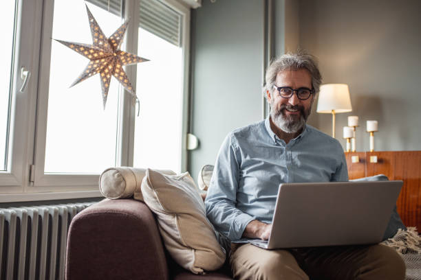 istock Modern senior man with laptop at home 1285113875
