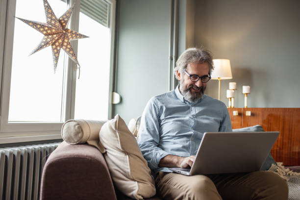 istock Modern senior man with laptop at home 1285113890