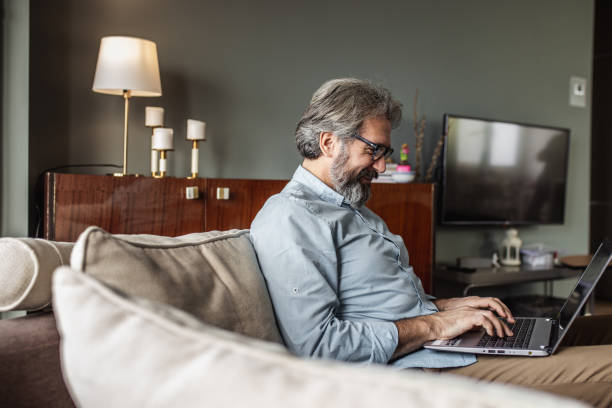 istock Modern senior man with laptop at home 1285113899