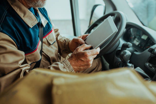 istock Close up of delivery man checking order on digital tablet 1285115172