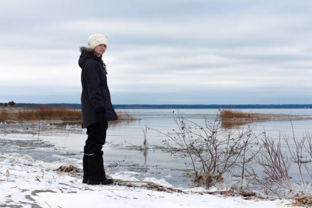 istock girl looking out at freezing lake 1285118208