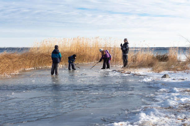 Family playing pond hockey