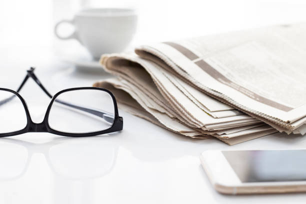 istock Newspapers and coffee cup, with reading glasses. 1285118458