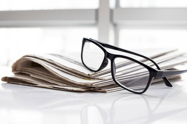 istock glasses on a daily newspaper. 1285118461
