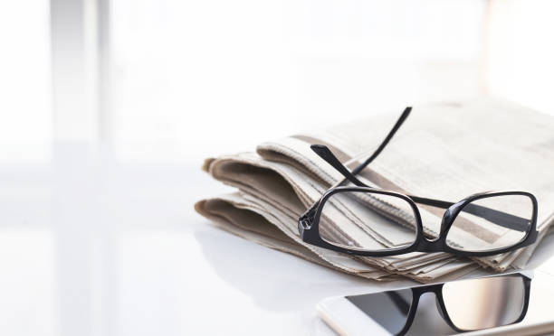 istock Newspapers and coffee cup, with reading glasses. 1285118551