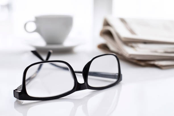 istock Newspapers and coffee cup, with reading glasses. 1285118613