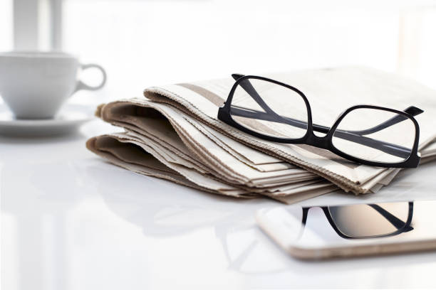 istock Newspapers and coffee cup, with reading glasses. 1285118636