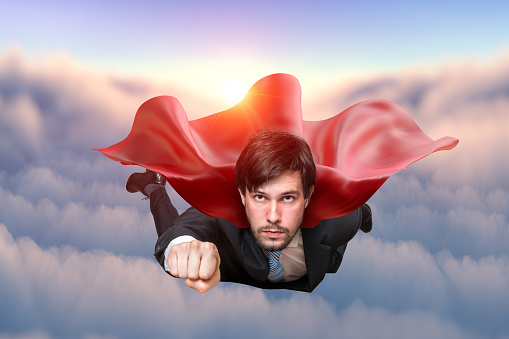 Brave businessman in suit is flying in sky as superhero.
