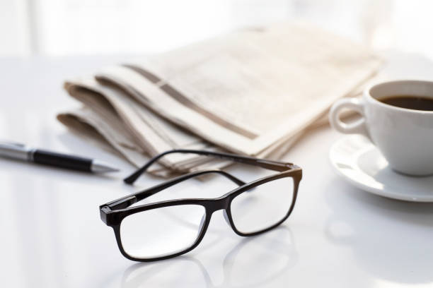 istock Newspapers and coffee cup, with reading glasses. 1285121319