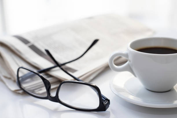 istock Newspapers and coffee cup, with reading glasses. 1285121569