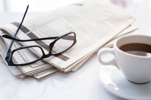 istock Newspapers and coffee cup, with reading glasses. 1285121754
