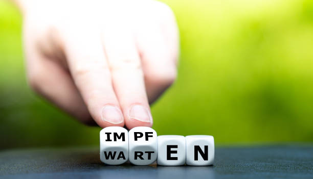 istock Symbol for a developed Corona vaccine. Hand turns dice and changes the German word 