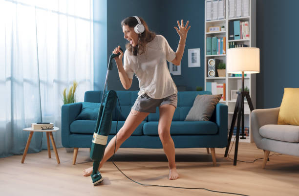 mujer limpiando su casa y cantando - musical feel fotografías e imágenes de stock