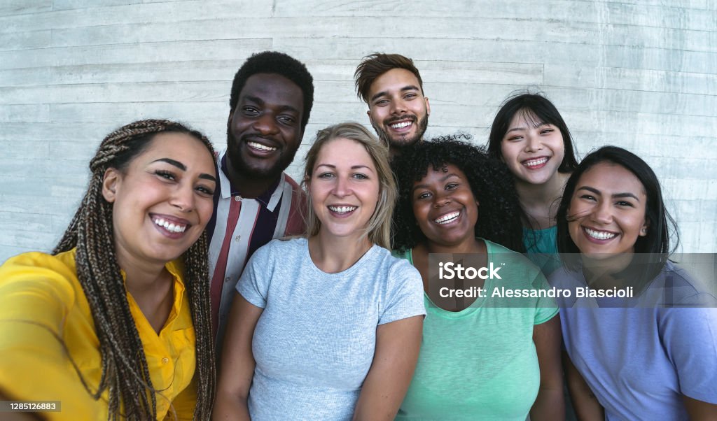 Group multiracial friends having fun outdoor - Happy mixed race people taking selfie together - Youth millennial generation and multi ethnic teenagers lifestyle concept Multiracial Group Stock Photo