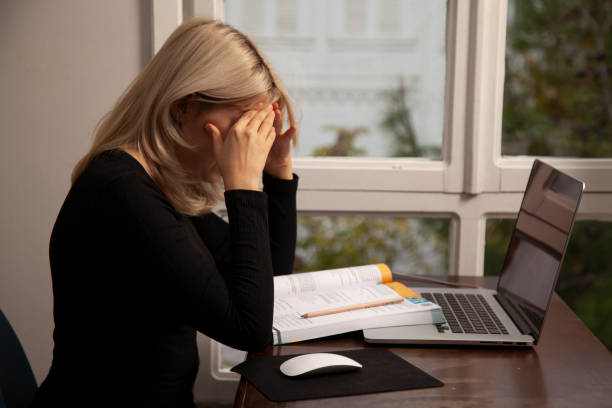 istock Young woman working on laptop and with test books 1285128514