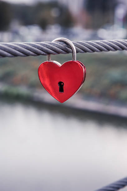 istock Lonely red heart padlock with cityscape background 1285130932