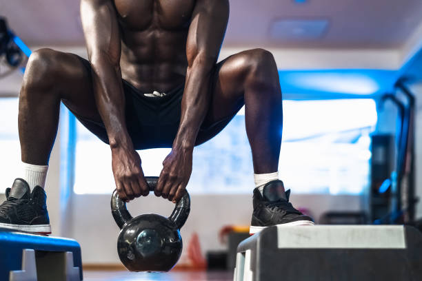istock Young African man training inside gym - Fit male doing kettlebell exercise workout session in sport club center - Fitness and bodybuilding lifestyle concept 1285131239