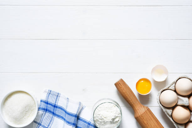 istock Baking ingredients: flour, eggs, sugar with a rolling pin on a light white wood background. With copy space. 1285132716