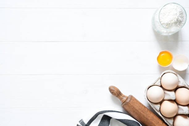 istock Baking ingredients: flour, eggs, sugar with a rolling pin on a light white wood background. With copy space. 1285132717