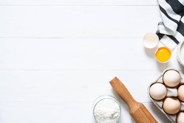istock Baking ingredients: flour, eggs, sugar with a rolling pin on a light white wood background. With copy space. 1285132718