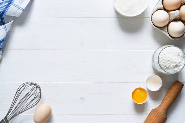 istock Baking ingredients: flour, eggs, sugar with a rolling pin on a light white wood background. With copy space. 1285132734