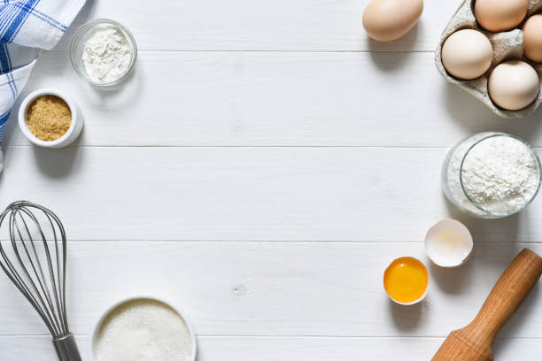 istock Baking ingredients: flour, eggs, sugar with a rolling pin on a light white wood background. With copy space. 1285132738