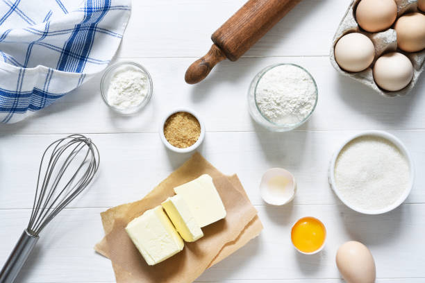 istock Baking ingredients: flour, eggs, sugar with a rolling pin on a light white wood background. . 1285132741