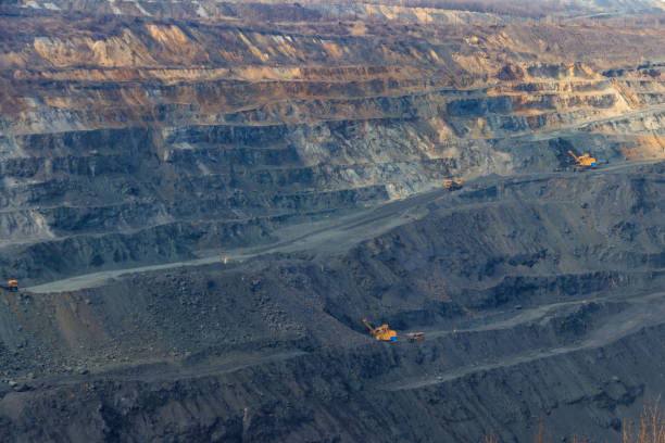 istock Huge iron ore quarry with working dump trucks and excavators 1285132860