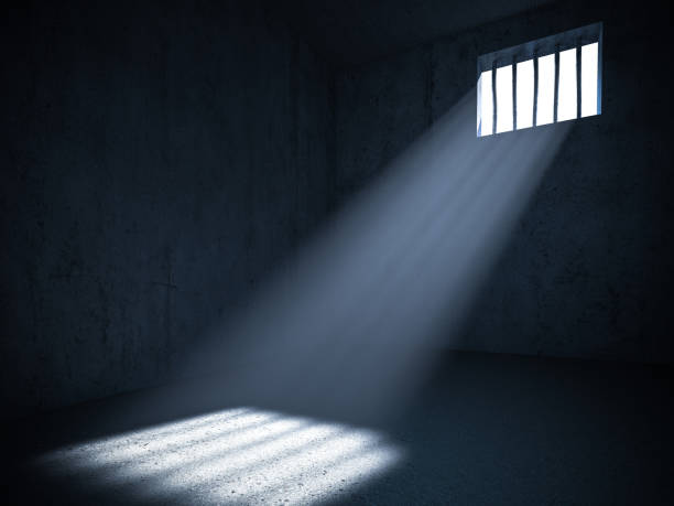 istock Interior of a prison with light from a barred window. 1285133926