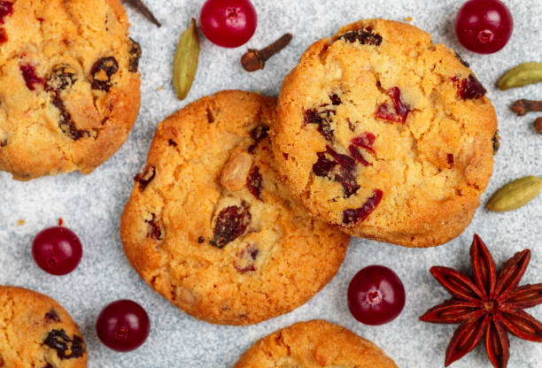 frisch gebackene hausgemachte kekse mit preiselbeeren, mandeln, weißer schokolade und gewürzen (zimt, kardamom, nelken, sternanis) aus nächster nähe. haferflocken kekse. weihnachten, neujahr. selektiver fokus - close up cookie gourmet food stock-fotos und bilder